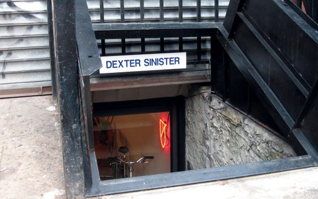 A below-ground outdoor entrance with a white sign and blue text reading 