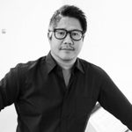 A man wearing glasses and a black shirt.