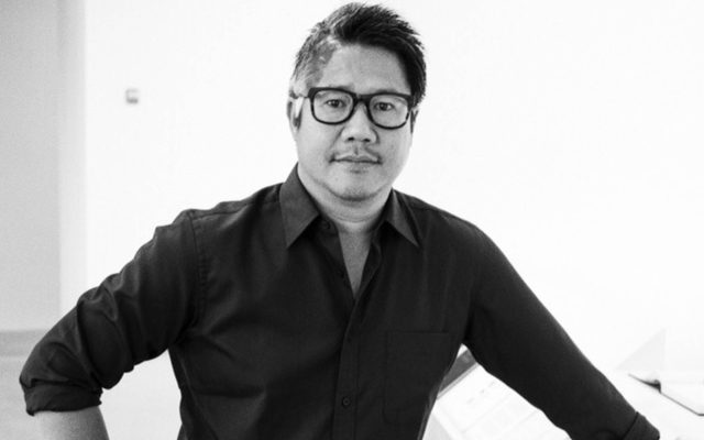 A man wearing glasses and a black shirt.