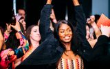 People smiling, dancing and raising their arms at an event at the Walker Art Center