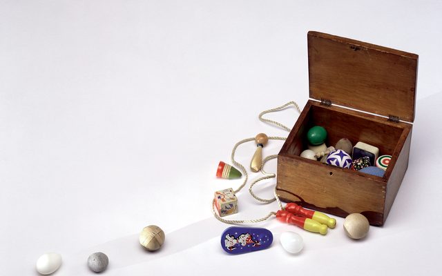 A small wooden box filled with small trinkets and some spread out on the table for display